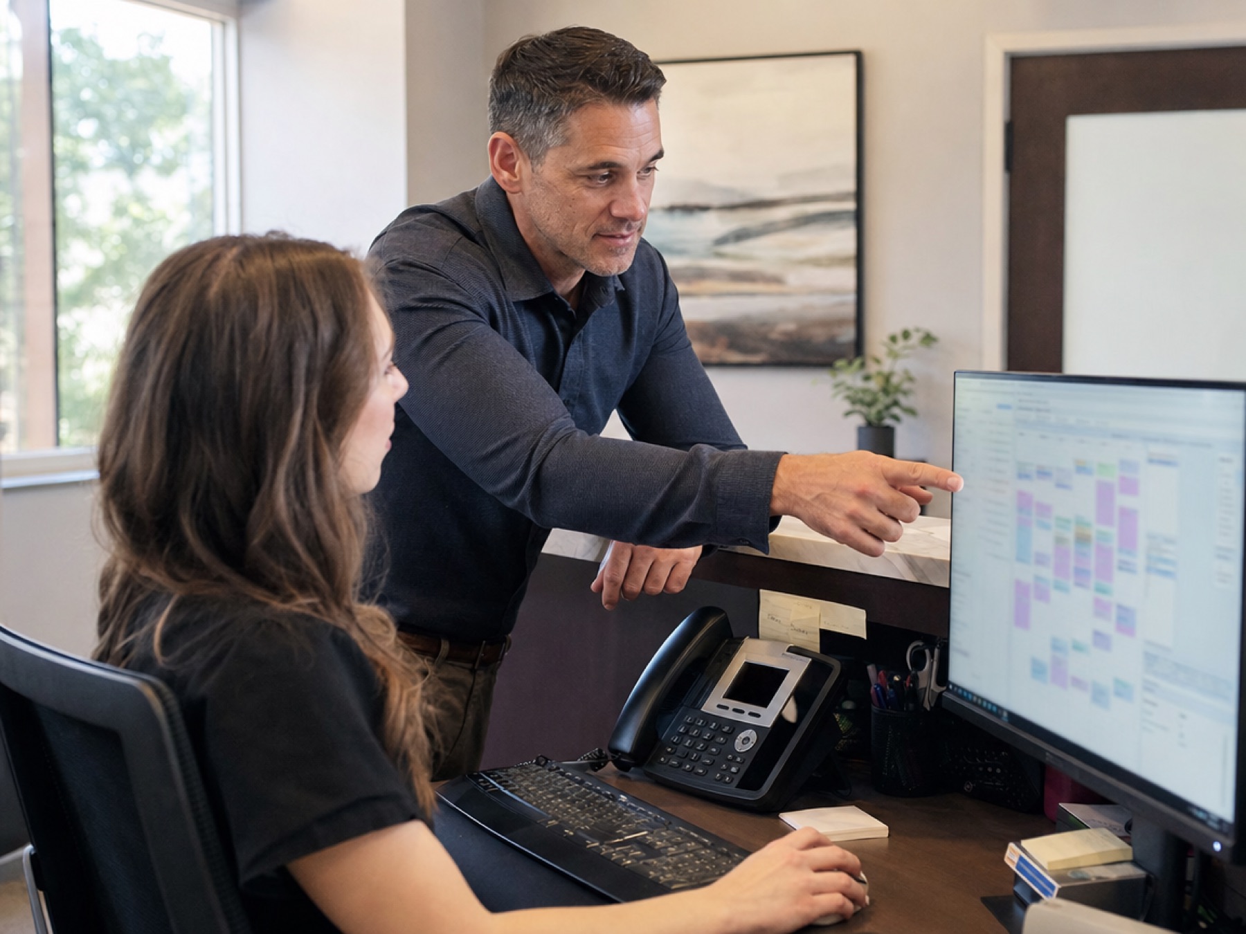 Chiropractor reviewing the schedule with a receptionist