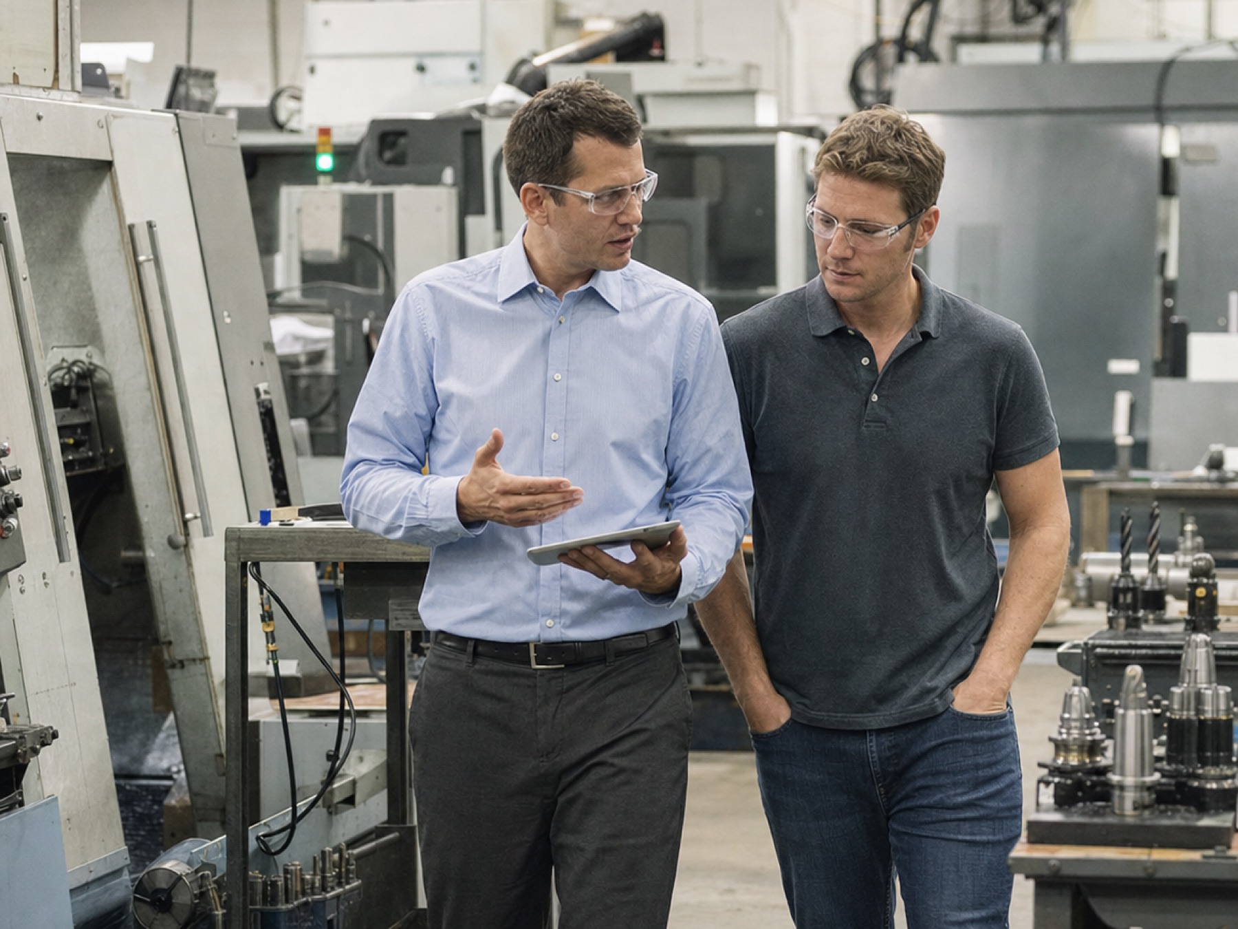 Sales manager walking a customer through a manufacturing floor