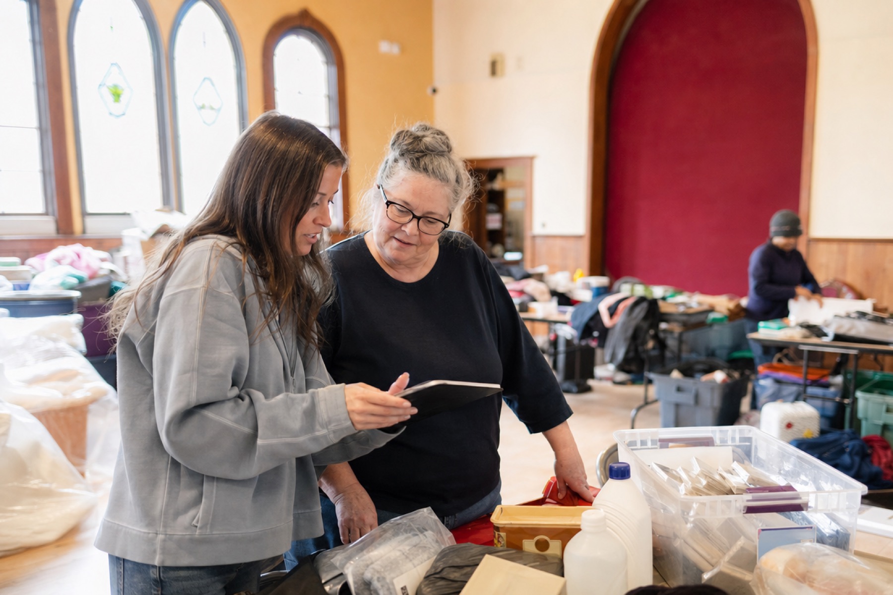 Nonprofit volunteers checking donor names on a tablet at a donation table